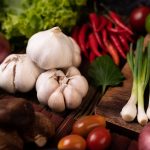 Garlic, tomato, shiitake mushroom, chili, and red onion on wooden slats. Selective focus.