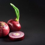 Red onions whole, isolated on a black background.